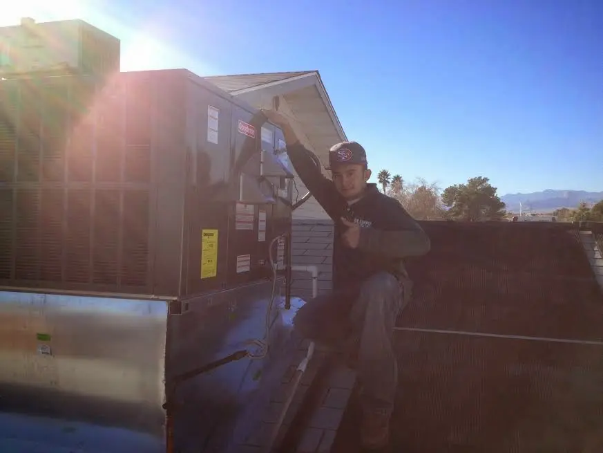 HVAC technician performing AC Tune-Up on a rooftop unit in Erlanger